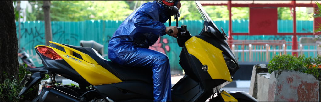 A man driving motorcycle wearing Ibex raincoat